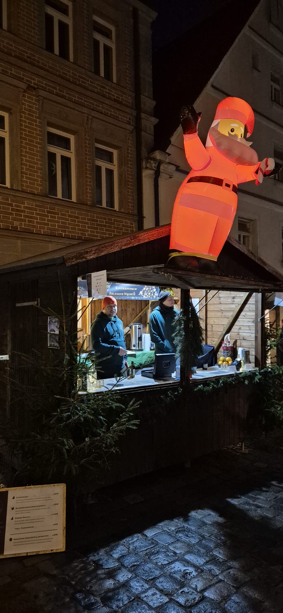 Der beleuchtete Stand am Weihnachtsmarkt bei Nacht